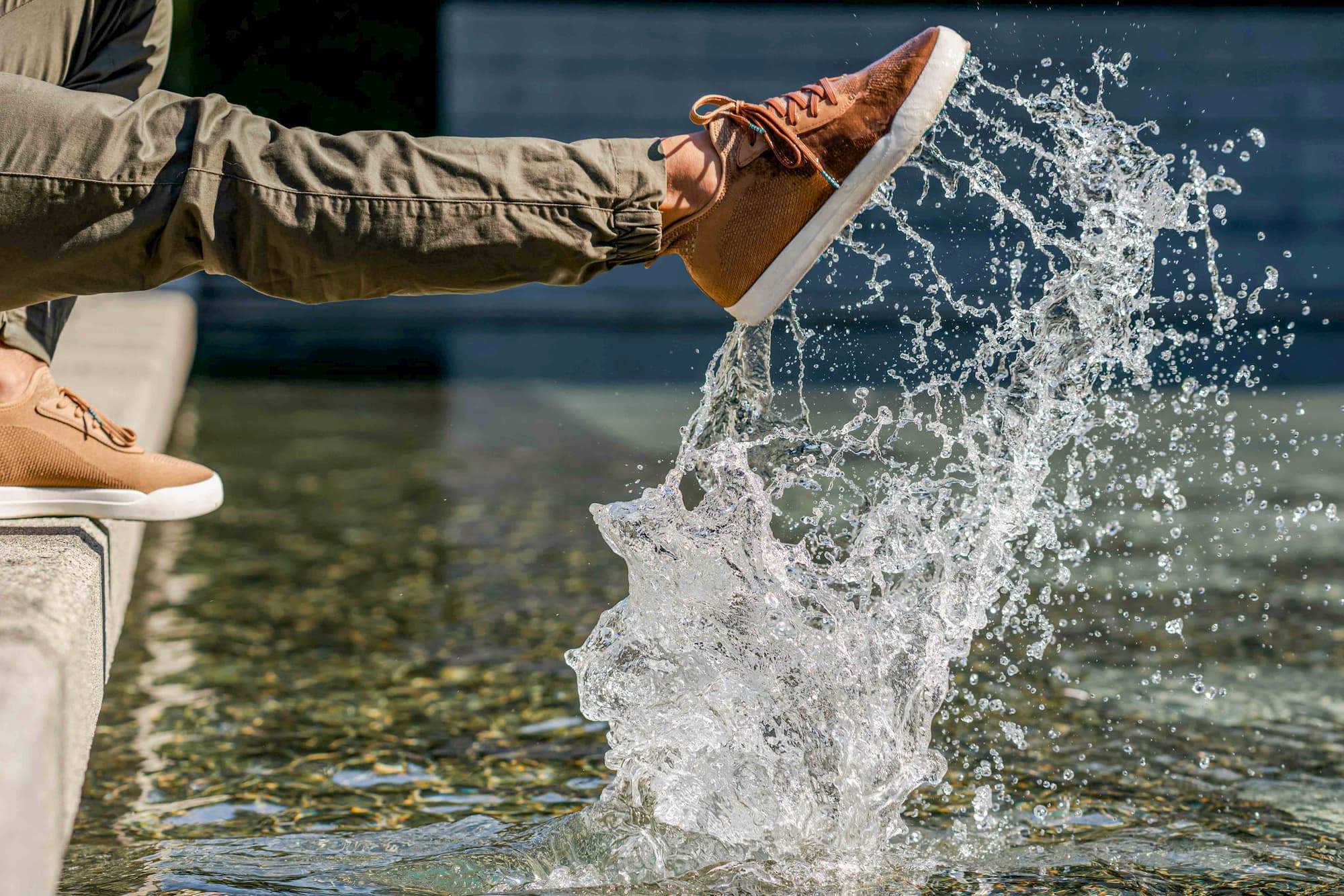 Person splashing their waterproof shoe in the water