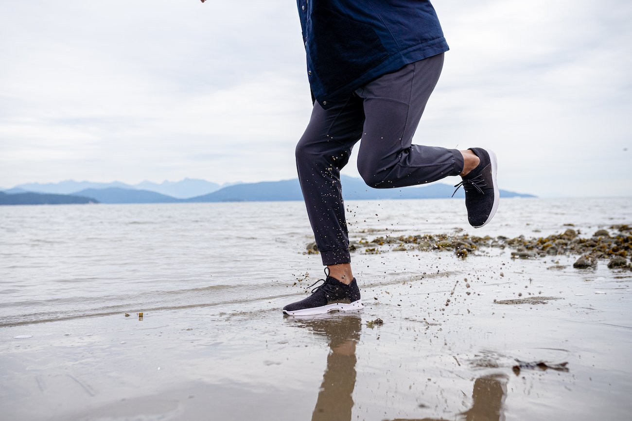 A man running on the beach wearing waterproof sneakers