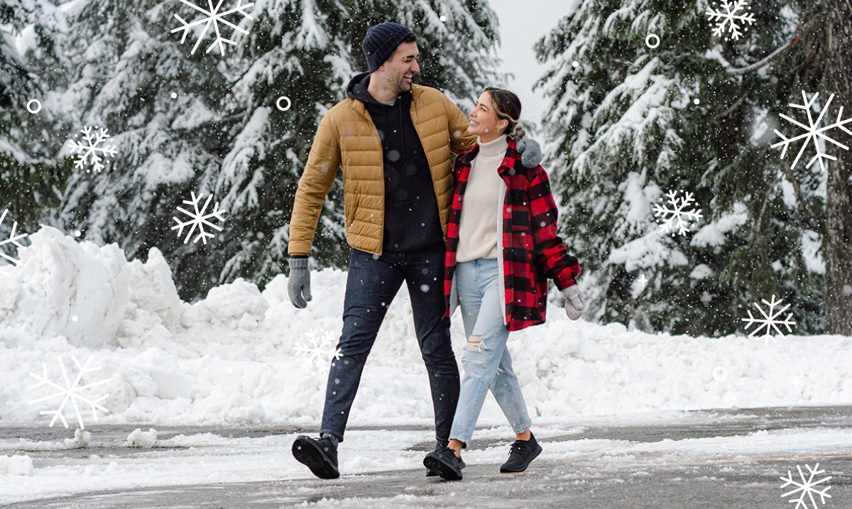 A man and a woman having a good time on a snowy day wearing Vessi waterproof shoes